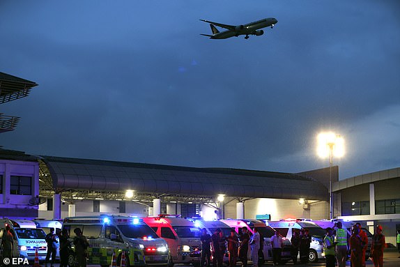 epa11358106 Rescue workers, medical personnels and emergency ambulance vehicles standby to transport injured passengers from a flight from London to Singapore to a hospital, after an emergency landing at Suvarnabhumi International Airport in Samut Prakan province, Thailand, 21 May 2024. According to Singapore Airlines, at least one person died and more than 30 passengers were injured when a Singapore Airlines plane travelling from London to Singapore was diverted to Bangkok in an emergency due to severe turbulence.  EPA/RUNGROJ YONGRIT